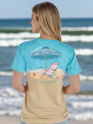 Simply Southern Tees
Printed on a dual toned tee 
features a beach chair, ocean, umbrella, and seashells 
