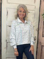 Cinched pullover top with snap collar neckline, dropped shoulders, long sleeves, and adjustable hem, women’s relaxed-fit casual pullover.
