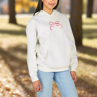 Person wearing a light gray hoodie with a pink bow design and light blue jeans on a white background