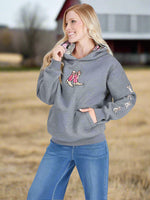 Woman wearing a gray hoodie with a graphic design on a light gray background
