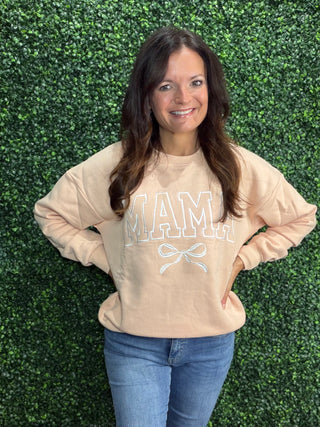 Simply Southern Crew Neck Sweatshirt 
Design: Mama (varsity letters) with a white bow design under it. Embroidered across the front of the crew 
Stitched on a light peach color crew