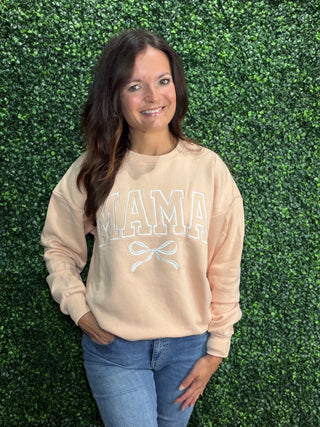 Simply Southern Crew Neck Sweatshirt 
Design: Mama (varsity letters) with a white bow design under it. Embroidered across the front of the crew 
Stitched on a light peach color crew