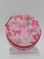 Pink round pouch with bow pattern on a white background
