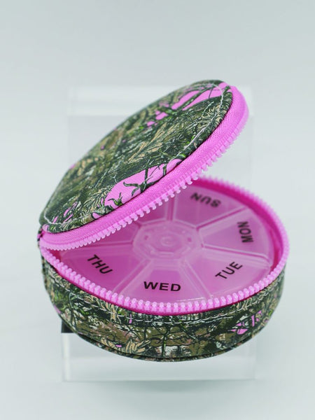 Pink and green pill organizer with floral pattern on a white background