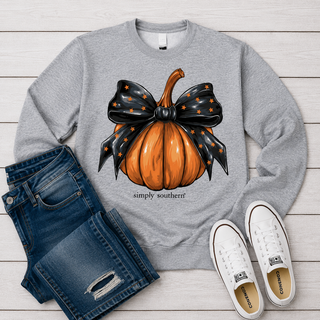 A heather gray crewneck sweatshirt featuring a graphic of an orange pumpkin under a black bow with orange stars, The text 'simply southern!' is printed below the graphic.