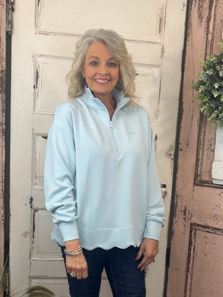 Simply Southern scalloped pullover top with zippered mock-neck neckline, dropped shoulders, and scalloped hem detail.