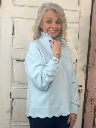 Simply Southern scalloped pullover top with zippered mock-neck neckline, dropped shoulders, and scalloped hem detail.