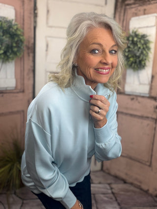 Simply Southern scalloped pullover top with zippered mock-neck neckline, dropped shoulders, and scalloped hem detail.