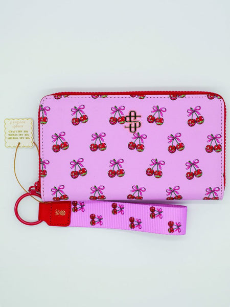 Pink wallet with cherry pattern and matching keychain on a white background