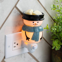 Adorable snowman pluggable fragrance warmer with rotating base. Ideal for small spaces, adds festive glow and scent—bulb included, flame-free.