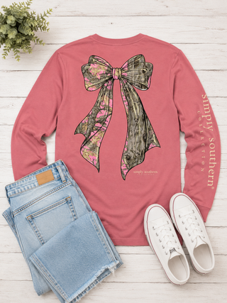 Brand | Simply Southern
Style | Long Sleeve Graphic Tee
Graphic | Oversized tree camo bow in pink and olive woodland print, back graphic
Sleeve Detail | "Simply Southern Collection" printed down the left sleeve
Color | Rose (Mauve Pink)
Neckline | Crew neck
Sleeve | Long sleeve
Fabric | 100% Cotton — soft, breathable, and easy to care for
Care | Machine wash cold, tumble dry low
