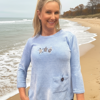 Plush sweater with turtle embroidery light blue.