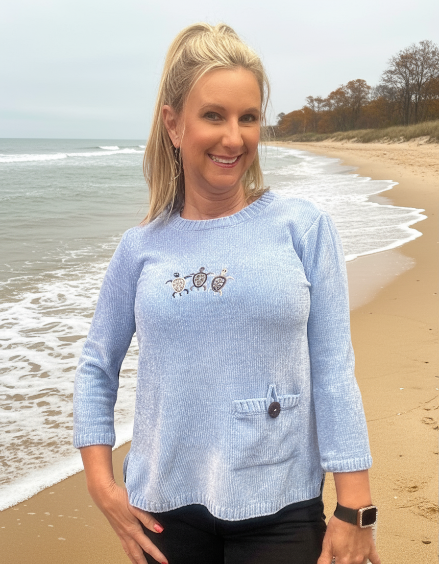 Plush sweater with turtle embroidery light blue.