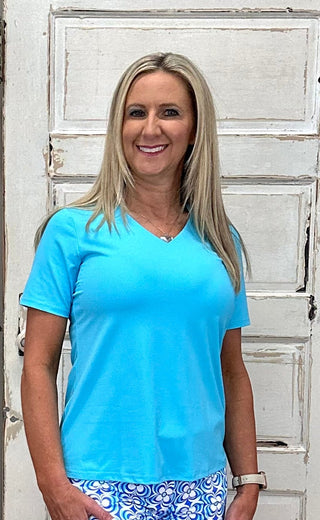 The Lulu-B V-Neck Short Sleeve Top in Turquoise is crafted from lightweight, cooling fabric with UPF 50 protection — that bright, clear turquoise hue brings an instant coastal energy to any outfit, whether you're pairing it with white denim for a casual day out or tucking it into a linen skirt for something more polished.