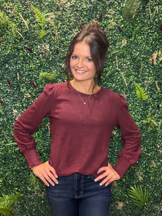 Reach for this elevated wine long sleeve top when you want everyday comfort with a little more polish. Its soft brushed feel, relaxed silhouette, and subtle sleeve detail make it an easy choice for workdays, weekend plans, and everything in between.

Key Details
Fit | Relaxed silhouette
Fabric Feel | Soft brushed rayon, polyester, and spandex blend
Neckline | Classic crew neckline
Sleeves | Long puff sleeves with smocked cuffs
Color | Wine