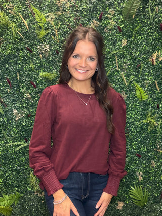 Reach for this elevated wine long sleeve top when you want everyday comfort with a little more polish. Its soft brushed feel, relaxed silhouette, and subtle sleeve detail make it an easy choice for workdays, weekend plans, and everything in between.

Key Details
Fit | Relaxed silhouette
Fabric Feel | Soft brushed rayon, polyester, and spandex blend
Neckline | Classic crew neckline
Sleeves | Long puff sleeves with smocked cuffs
Color | Wine
