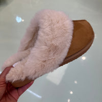 Brown slipper with fluffy white lining.